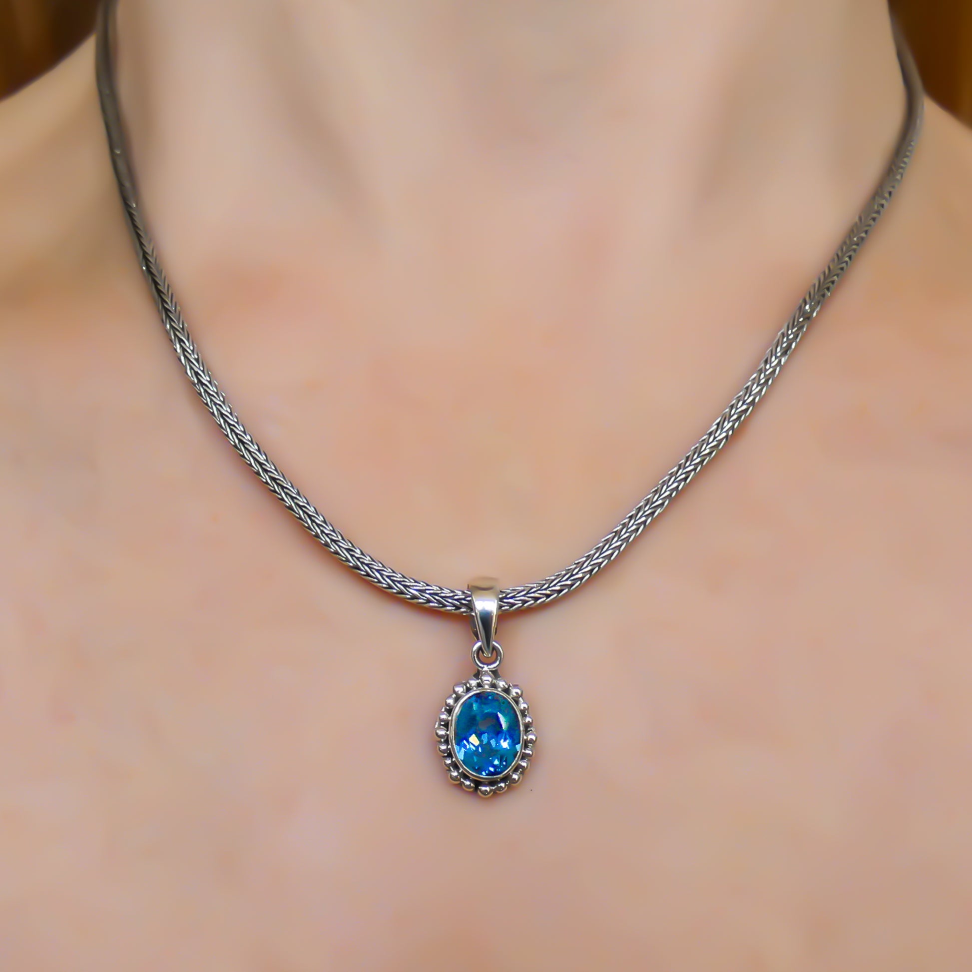 Sterling silver and oval blue topaz pendant.