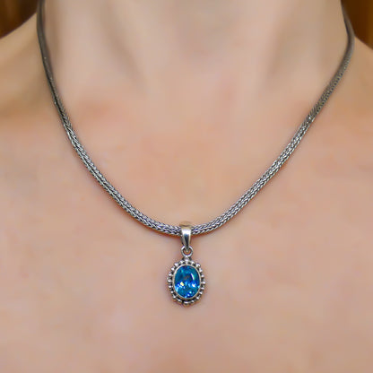 Sterling silver and oval blue topaz pendant.