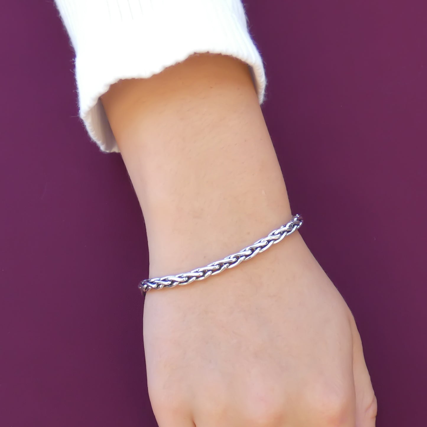 Woman wearing a thick silver wheat chain bracelet.