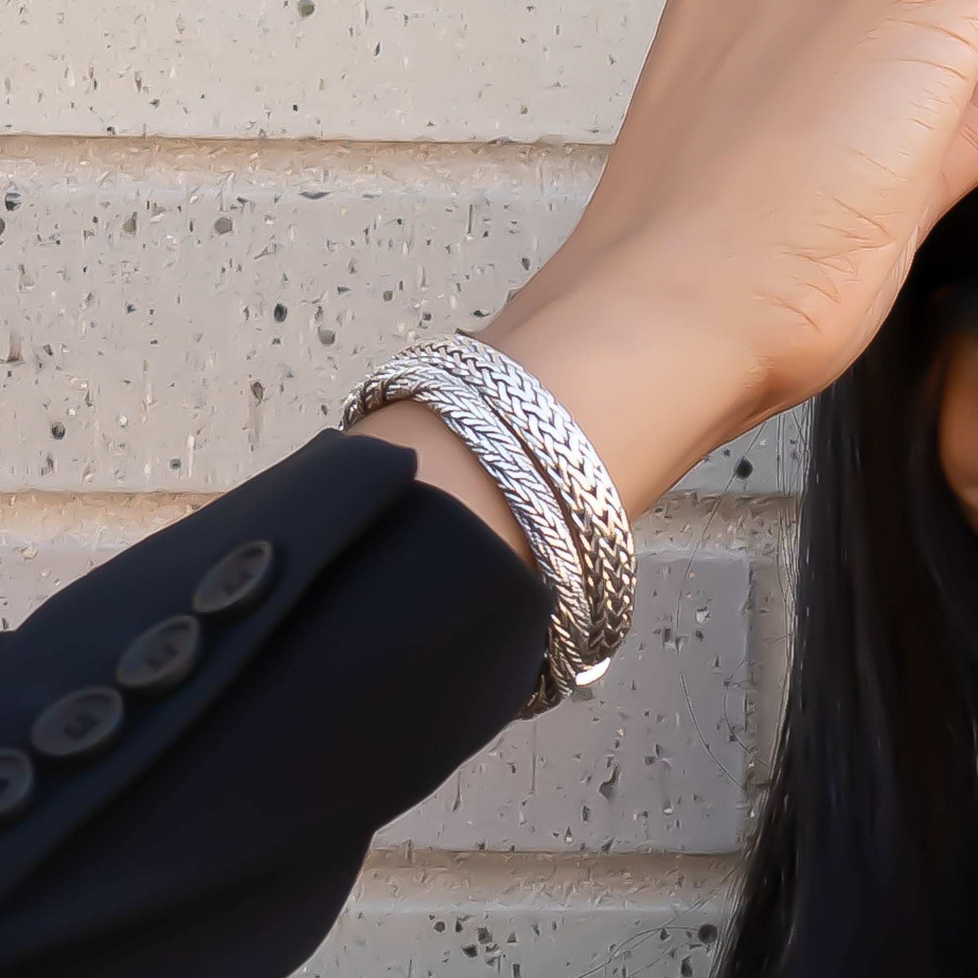 Woman wearing two silver snake chain bracelets.