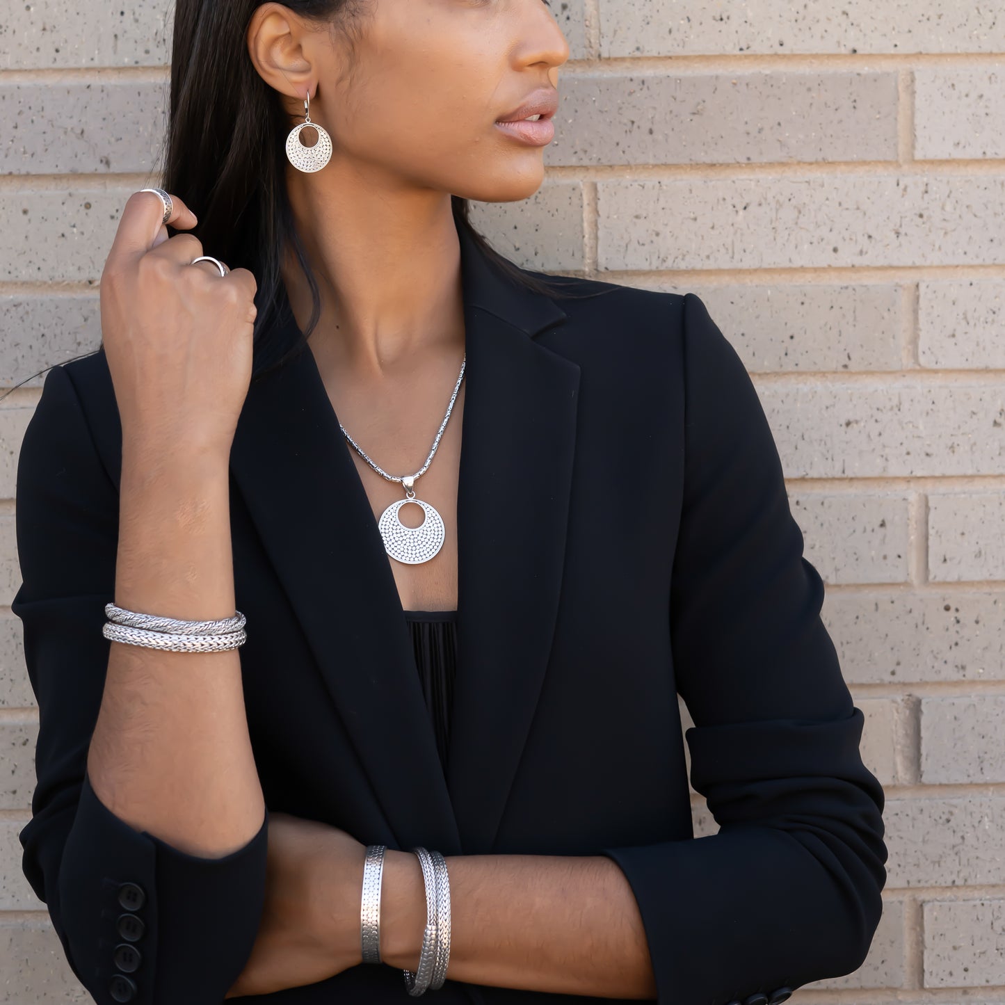 Woman wearing a variety of silver jewelry.