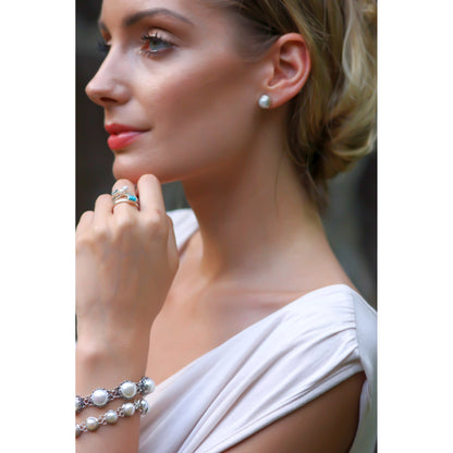 Woman wearing silver and pearl jewelry.