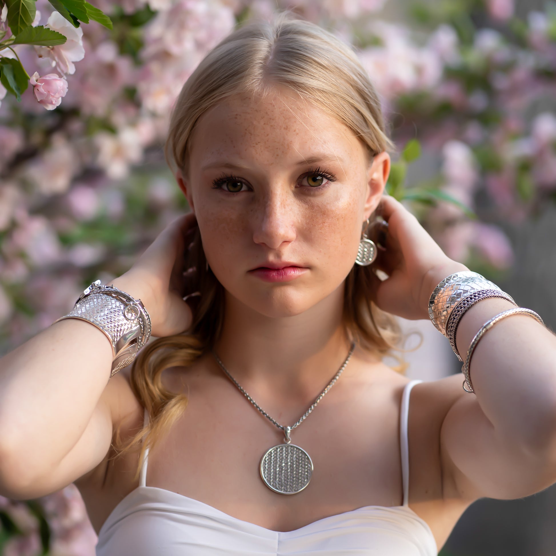Woman wearing a variety of silver jewelry.