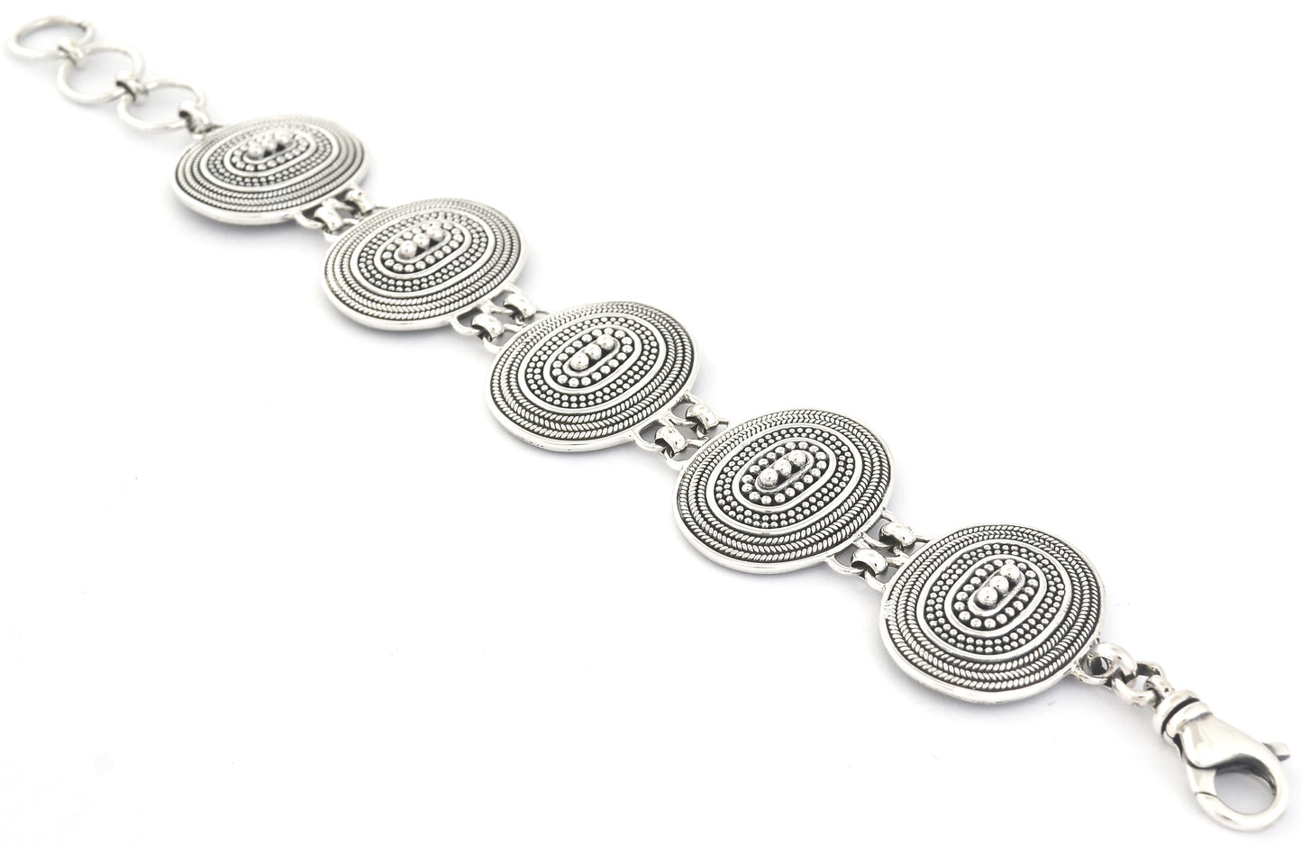 Silver bracelet laid out flat with oval link stations.